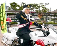 　伊藤将は甲子園署の一日警察署長を務め、白バイにまたがり笑顔で敬礼をする（撮影・山口登）