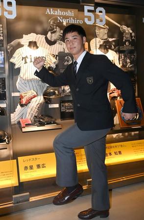 　展示の前で活躍を誓う井坪（撮影・飯室逸平）