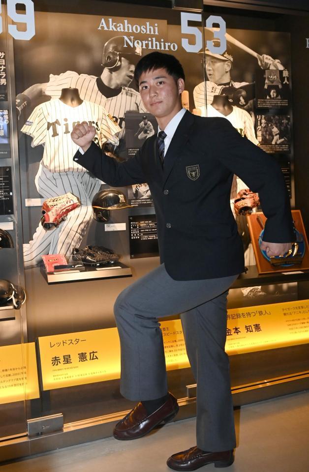 　展示の前で活躍を誓う井坪（撮影・飯室逸平）