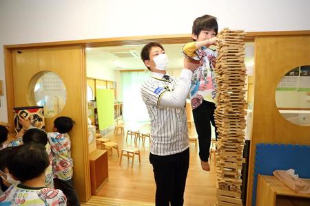 　寄贈した玩具で園児と遊ぶ岩崎＝西宮市立浜甲子園保育所（球団提供）