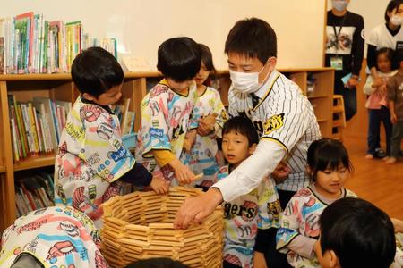 　寄贈した玩具で園児と遊ぶ岩崎＝西宮市立浜甲子園保育所（球団提供）