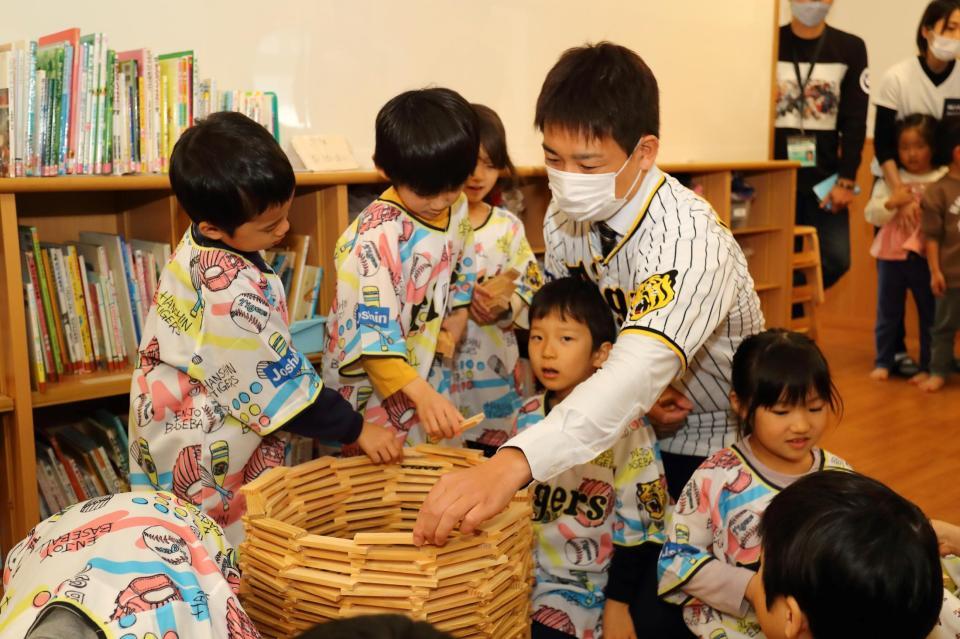 　寄贈した玩具で園児と遊ぶ岩崎＝西宮市立浜甲子園保育所（球団提供）