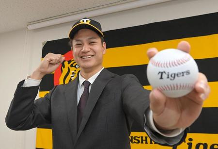 　入団会見を終え、笑顔でポーズを決める大竹（撮影・高部洋祐）