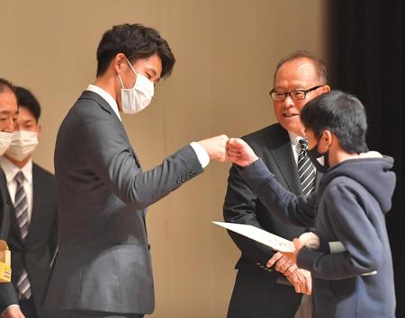 　参加者にプレゼントを贈りタッチを交わす富田（撮影・吉澤敬太）