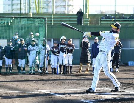 　練習の最後にバッティングを披露し、子どもを沸かせる近本（右）＝撮影・石井剣太郎