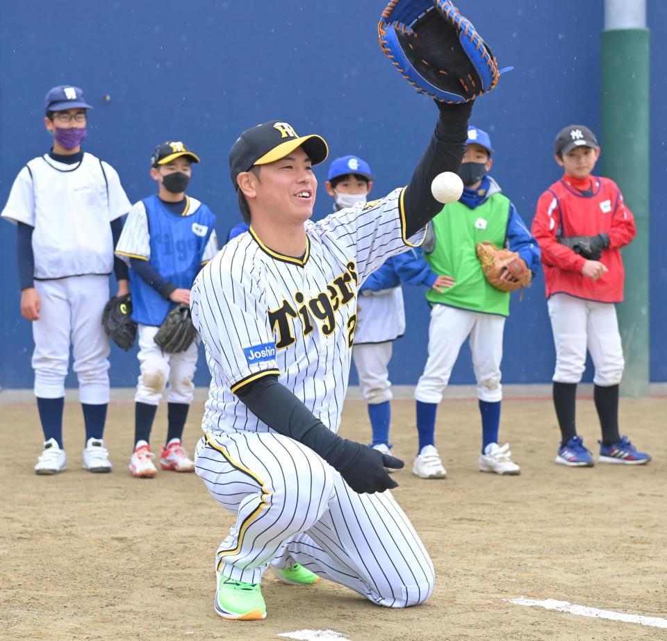 　子どもたちの前で、キャッチャーのお手本を見せる梅野（撮影・高部洋祐）