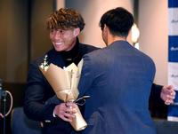 　佐藤輝（右）から花束を受け取り、笑顔を見せる糸井氏（撮影・田中太一）