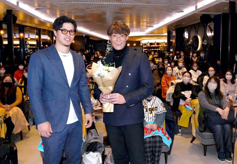 　糸井嘉男氏（右）に花束を渡し、記念写真に収まる佐藤輝（撮影・田中太一）