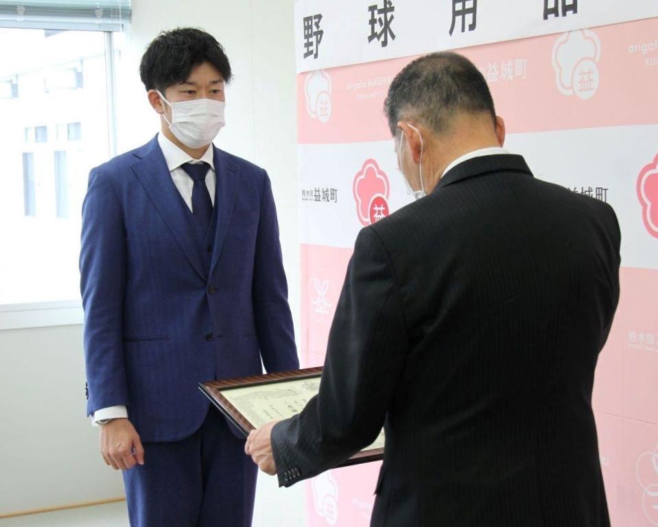 　益城町の西村博則町長から表彰状を授与する岩貞（球団提供）