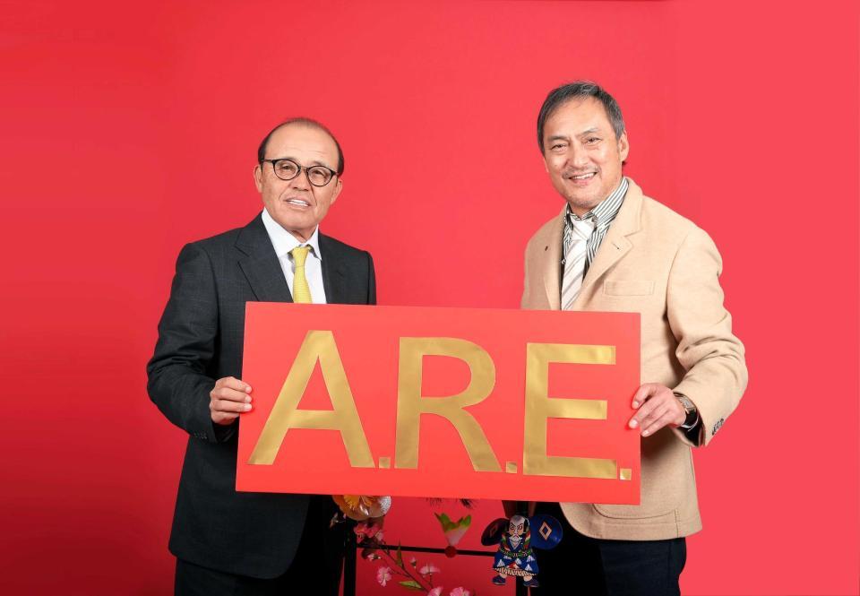 　スローガン「Ａ．Ｒ．Ｅ．」を手にする岡田監督（左）と渡辺謙（撮影・堀内翔）