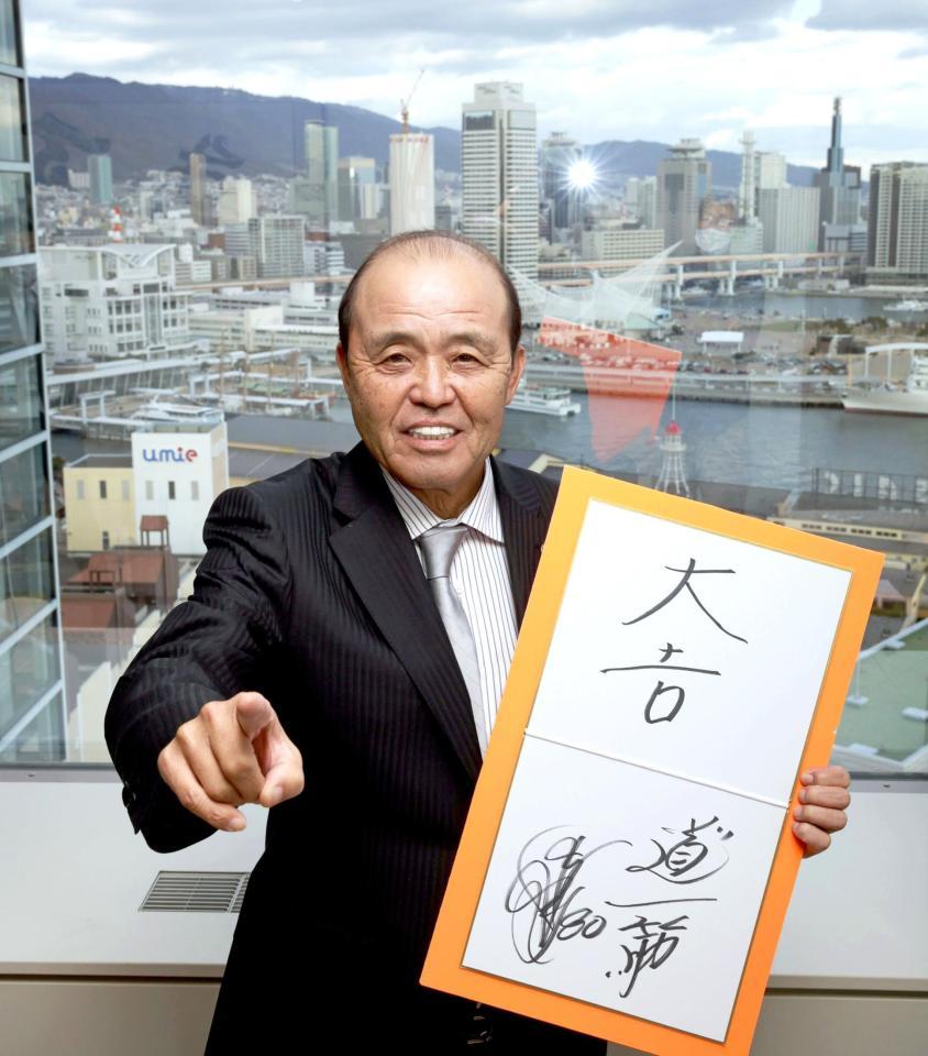 　神戸の街並みを背に笑顔でポーズを決める岡田監督（撮影・坂部計介）