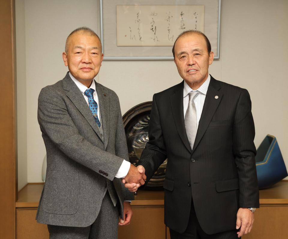 　岡田監督（右）と握手をかわすデイリースポーツ・改発代表取締役社長（撮影・坂部計介）