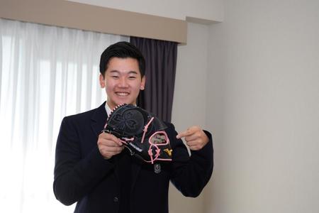 　入寮し自室で笑顔の門別（球団提供）