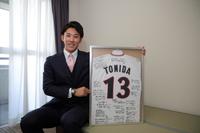 　入寮し自室で笑顔の富田（球団提供）