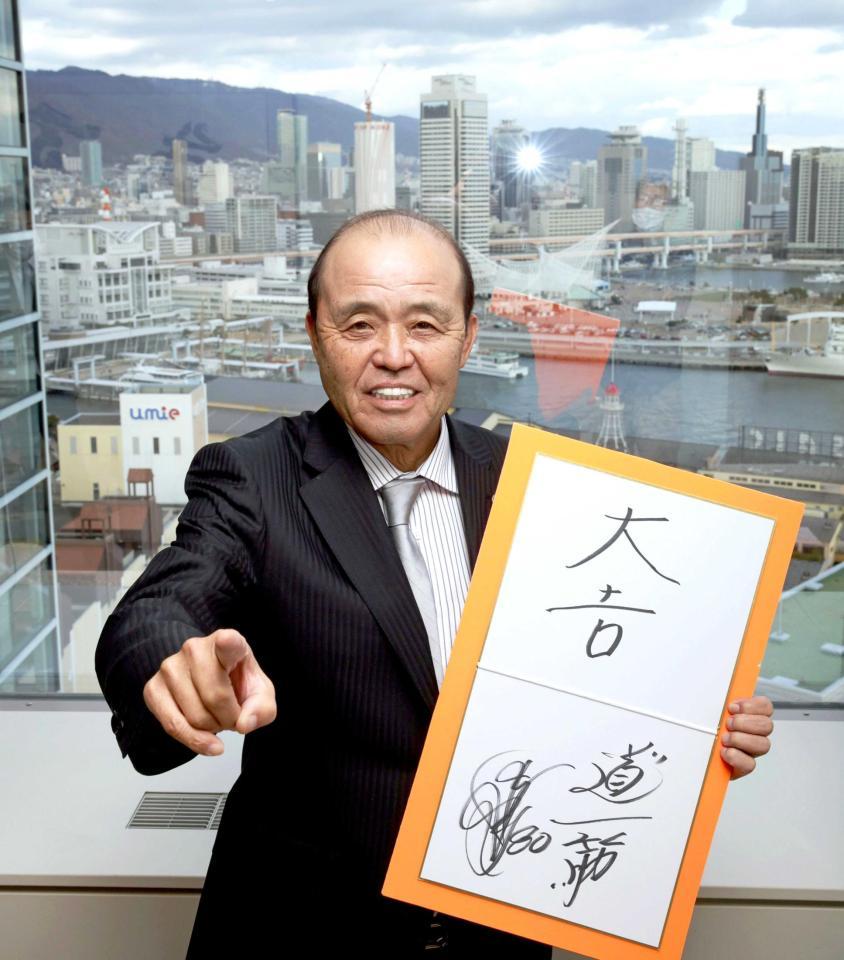 神戸の街並みを背に笑顔でポーズを決める阪神・岡田監督（撮影・坂部計介）