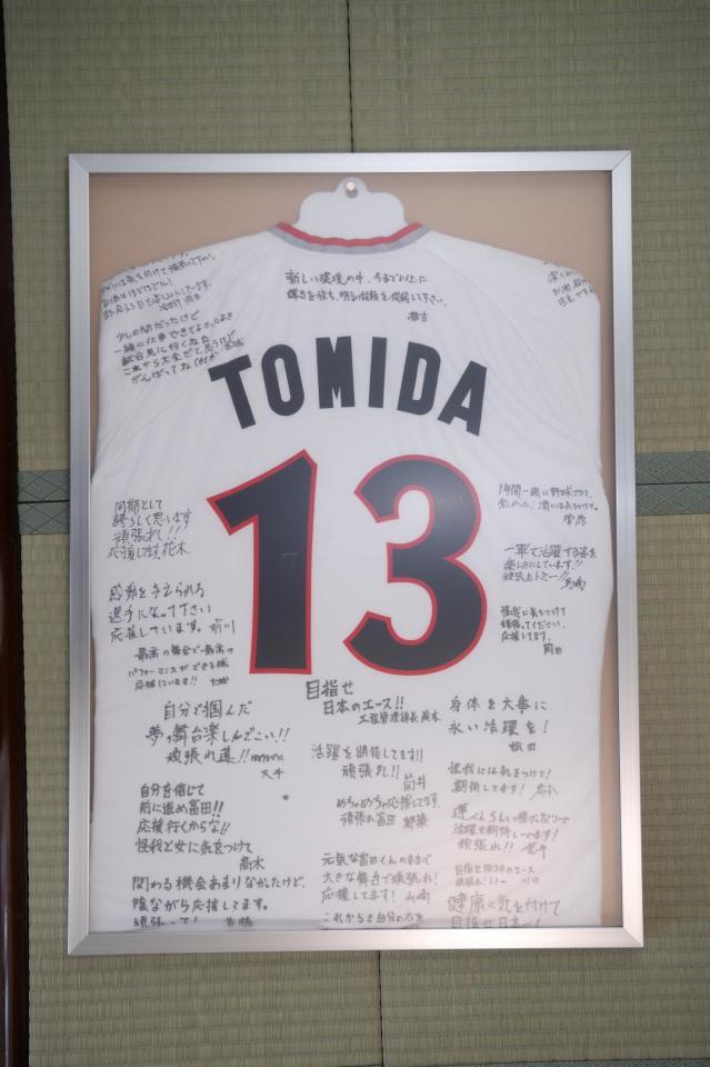 　富田が持参した寄せ書き入りのユニホーム（球団提供）