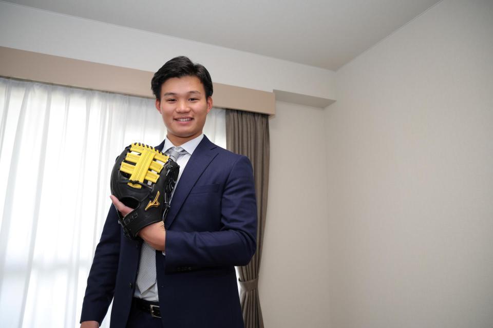 　入寮し持参したグラブを手に笑顔の森下（球団提供）