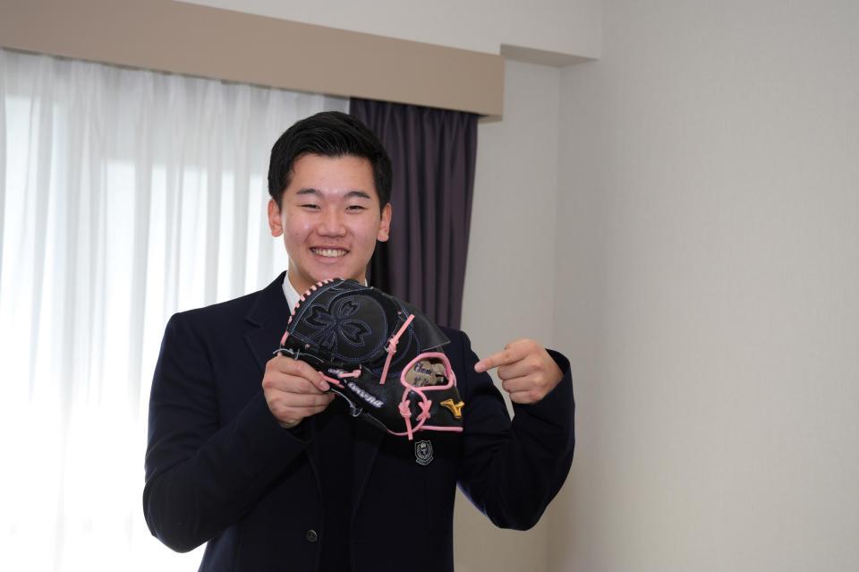 　入寮し自室で笑顔の門別（球団提供）