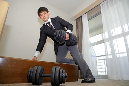 　入寮し自室で持参したダンベルを持つ野口（球団提供）