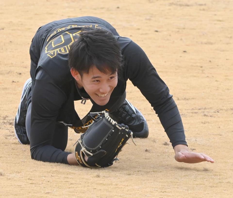 打球に飛びつき笑顔を見せる阪神・富田蓮＝鳴尾浜（撮影・高部洋祐）