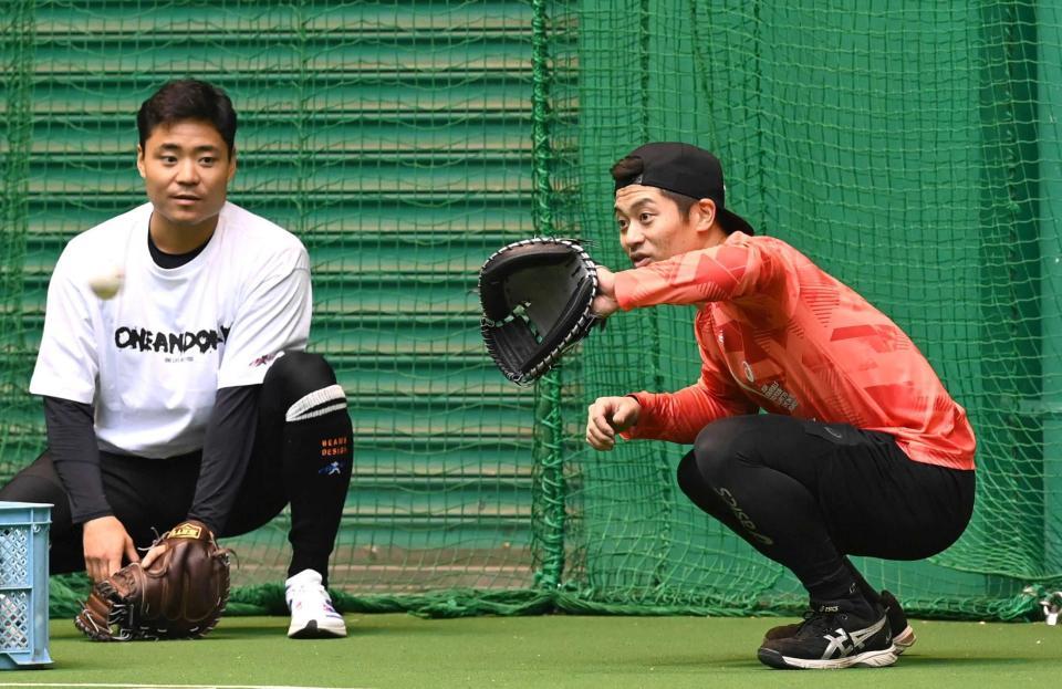 　中村（左）と話をしながら捕球練習をする坂本