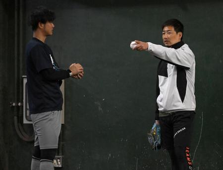 　ブルペンで投げ込む川原（左）にアドバイスをする岩崎（撮影・伊藤笙子）