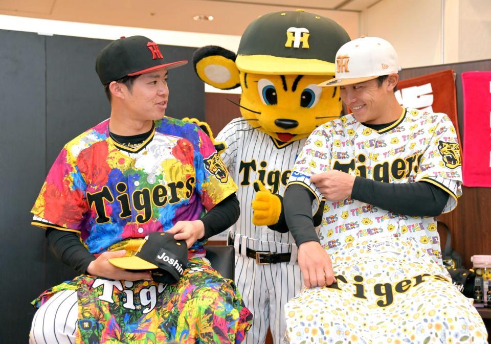 　阪神タイガースのグッズ内覧会でデザインユニホームに袖を通す中野（左）と熊谷