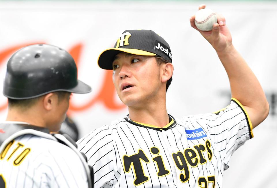 　ブルペンで投球後、坂本（左）と話し込む伊藤将（撮影・中田匡峻）