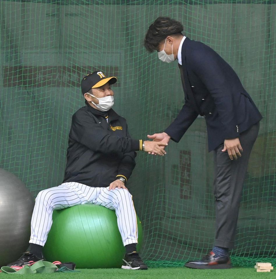 　糸井嘉男氏（右）と握手する岡田監督（撮影・高部洋祐）