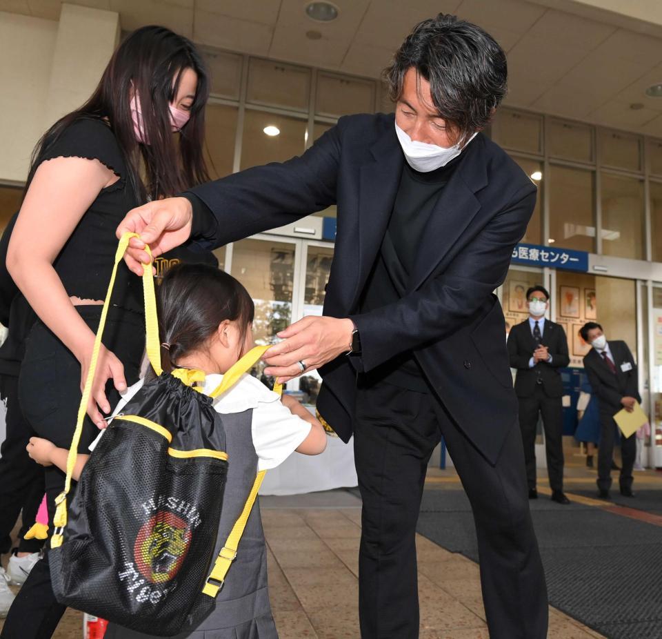 　子どもにリュックを背負わせてあげる鳥谷氏