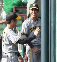 　９回から登板し、無失点に抑えた富田は江草コーチ（左）と笑顔で談笑する（撮影・北村雅宏）