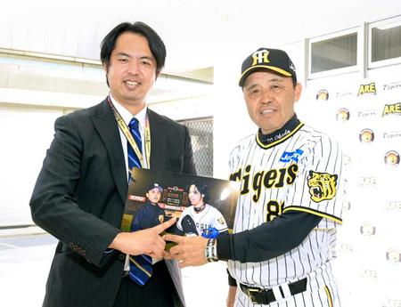 　２００４年のツーショット写真を懐かしみ笑顔を見せるデイリースポーツ評論家・井川氏（左）と岡田監督（撮影・立川洋一郎）
