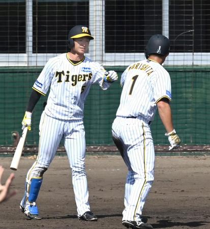 　３回、生還した森下（１）を出迎える近本（撮影・飯室逸平）