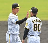 　キャンプを打ち上げ、岡田監督（右）とタッチを交わす森下（撮影・西岡正）