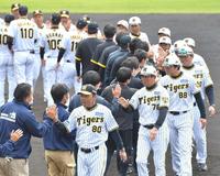 　キャンプを打ち上げ、ナインやスタッフらとタッチを交わす岡田監督（手前）＝撮影・西岡正