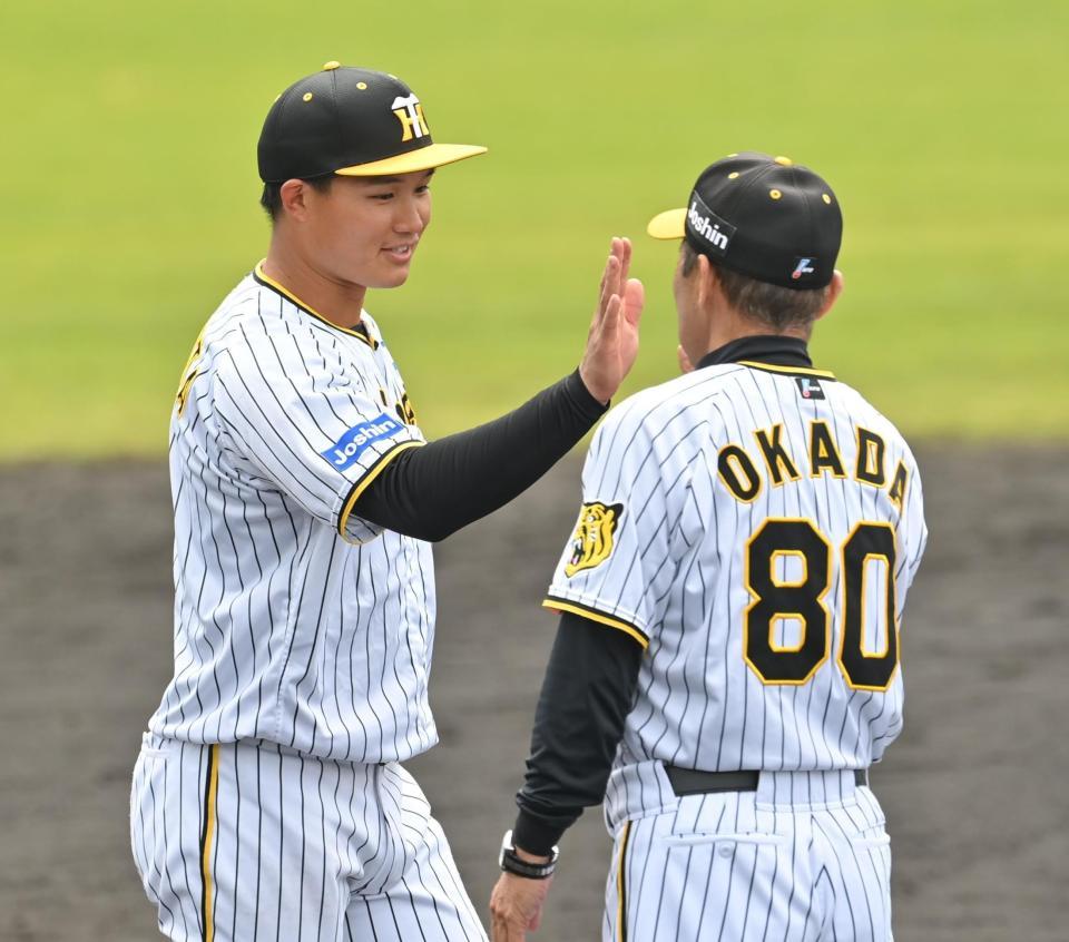 　キャンプを打ち上げ、岡田監督（右）とタッチを交わす森下（撮影・西岡正）