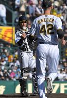 　５回、登板するＫ・ケラーにボールをトスする梅野（左）＝撮影・北村雅宏