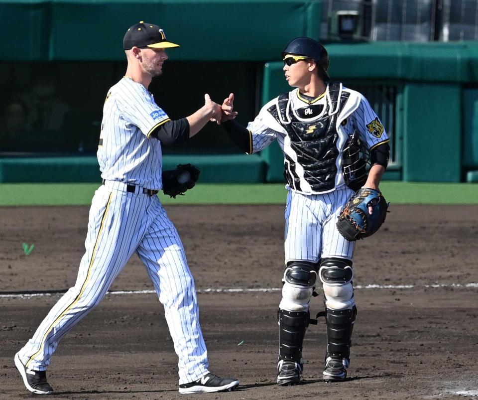 　５回、Ｋ・ケラー（左）とタッチを交わす梅野（撮影・飯室逸平）