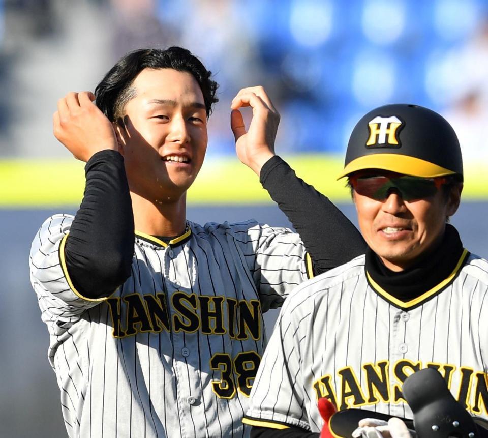 　８回表の攻撃を終え、藤本内野守備走塁コーチ（右）に道具を渡した小幡は笑顔を見せる（撮影・中田匡峻）