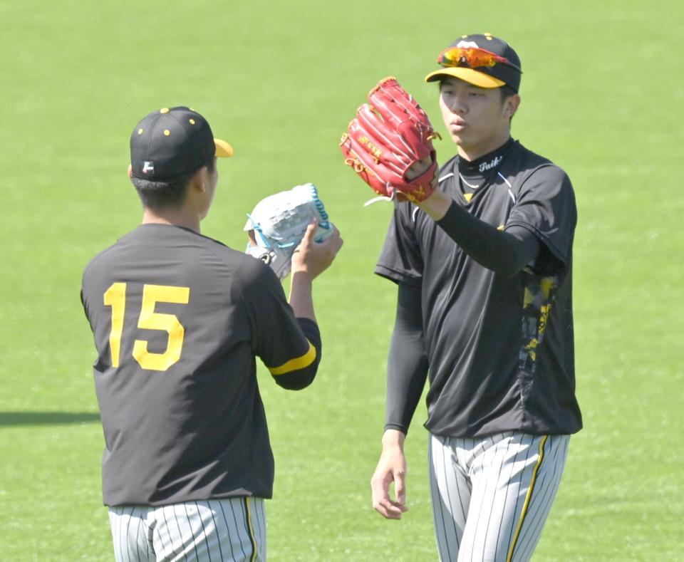 　キャッチボールを終えて西純（左）とグラブタッチする才木（撮影・西岡正）