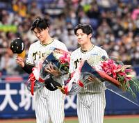 　世界一を祝福され花束を贈られる（左から）湯浅と中野（撮影・飯室逸平）