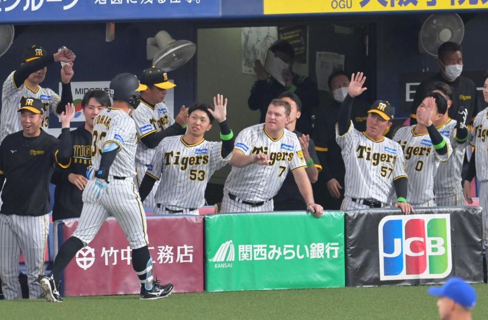 　８回、進塁打を放った代打・糸原をタッチで迎える阪神ベンチ（撮影・立川洋一郎）