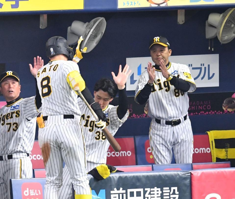 　５回、同点中犠飛を放った佐藤輝を拍手で迎える岡田監督（撮影・中田匡峻）