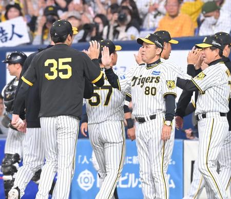 　ＤｅＮＡ相手に３連勝を飾り、才木（３５）とタッチを交わす岡田監督（撮影・高部洋祐）