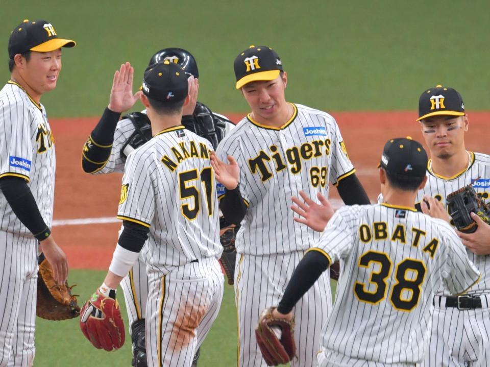 　９回を締めくくりナインとタッチを交わす石井（中央）＝撮影・立川洋一郎