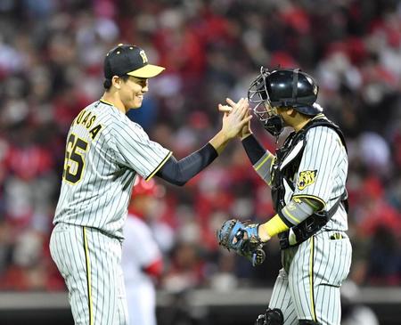 　９回を締めた湯浅（左）は梅野とハイタッチ（撮影・中田匡峻）