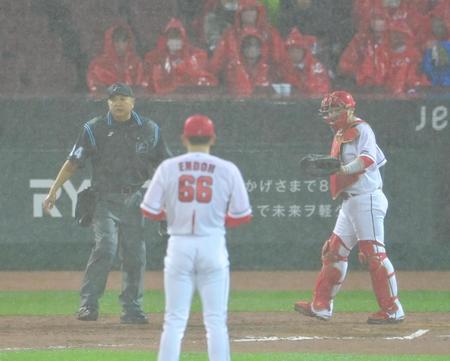 　降り続く雨が強さを増し試合を中断させる嶋田球審（撮影・立川洋一郎）