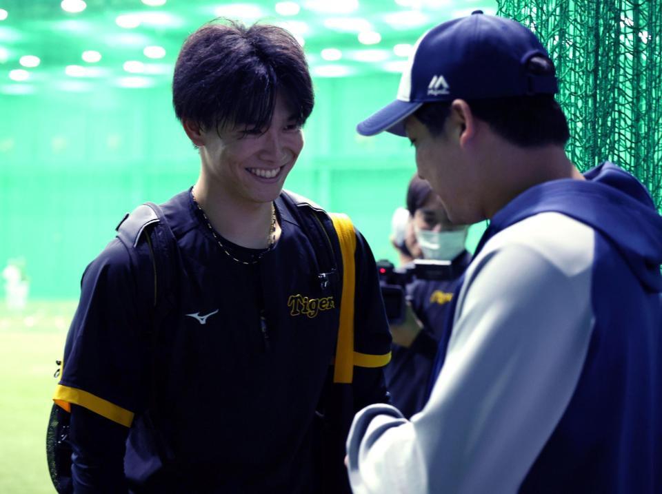 　湯浅（左）は山田に笑顔であいさつする（撮影・山口登）