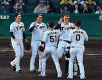 ヤクルトに勝利し、阪神・湯浅京己（左端） ら阪神ナインは笑顔えタッチする＝甲子園（撮影・山口登）