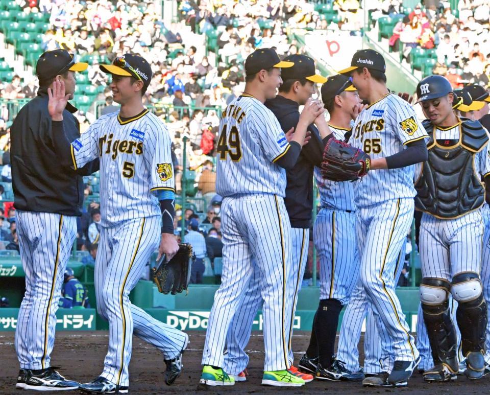 阪神・湯浅京己（６５）からウイニングボールを受け取る阪神・大竹耕太郎＝甲子園（撮影・立川洋一郎）